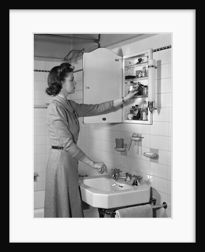 1940s woman reaching into bathroom medicine cabinet by Anonymous