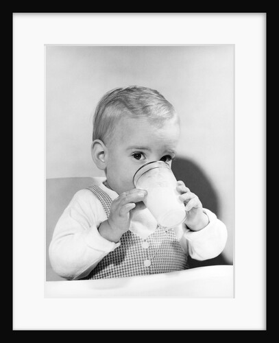 1950s boy toddler drinking glass milk looking at camera by Anonymous