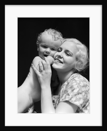 1930s blonde woman mother smiling holding baby to cheek by Anonymous