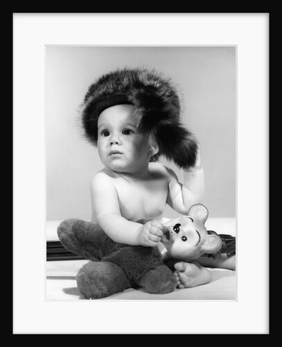 1960s baby wearing coonskin hat by Anonymous