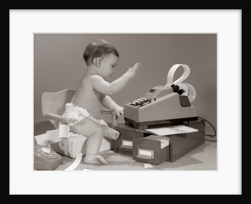 1960s baby seated in small chair hitting keys on office adding machine on top of small file drawers by Anonymous