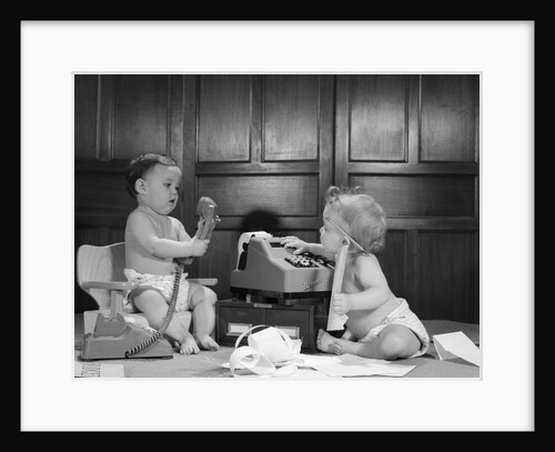 1960s 2 babies in diapers one on chair with telephone other on floor with adding machine pencil behind ear by Anonymous
