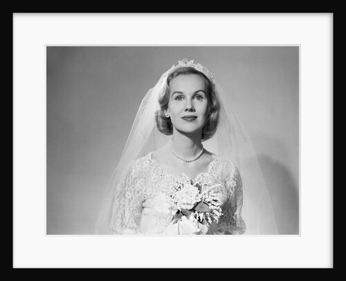 1950s portrait of woman bride wearing white wedding dress veil string of pearls holding a bouquet of flowers looking at camera by Anonymous