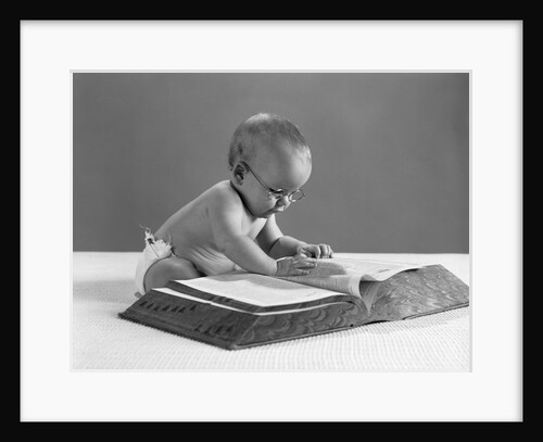 1960s baby wearing glasses looking for a word in big dictionary by Anonymous