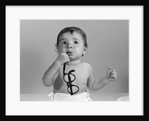 1960s baby in diaper chewing on eyeglasses by Anonymous