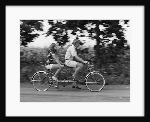 1970s teenage girl and boy riding bicycle built for two by Anonymous