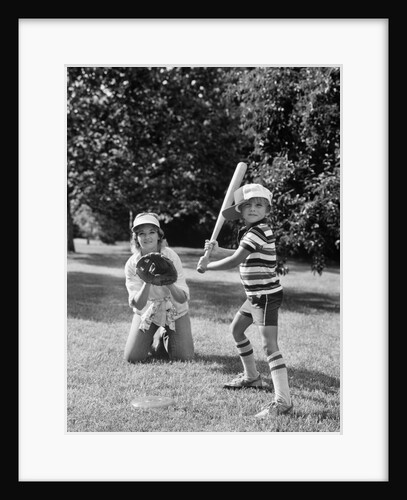 1980s boy at bat with mother kneeling behind him as catcher by Anonymous