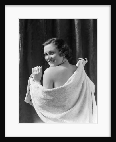 1930s smiling brunette woman looking over shoulder drying back with towel looking at camera by Anonymous