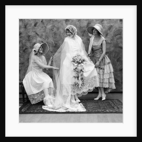 1900 1910s bride with one bridesmaid on either side helping fix her wedding dress by Anonymous