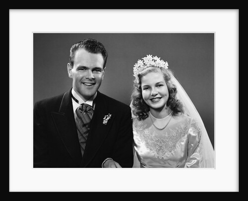 1940s portrait of bride and groom linked arm in arm looking at camera by Anonymous