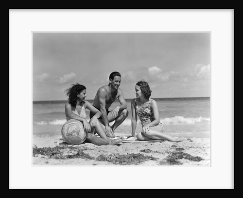 1930s 1940s two women one man in bathing suits sitting on beach by Anonymous