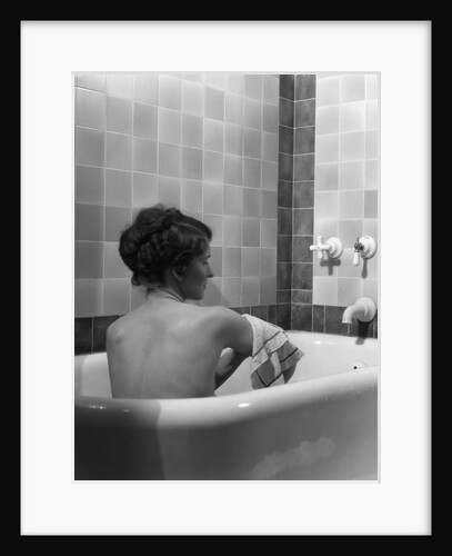 1920s 1930s young brunette woman sitting in luxury bathtub taking a bath by Anonymous