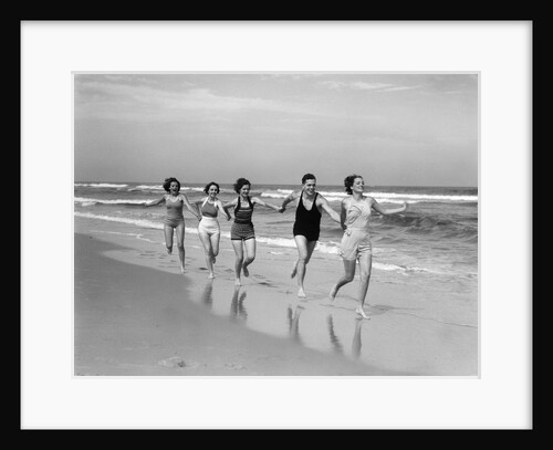1930s four women and one man running on beach holding hands by Anonymous