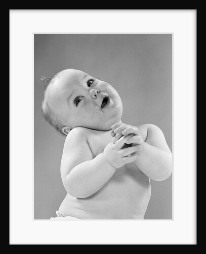 1950s baby in diaper head to one side arms hands clasped in front by Anonymous