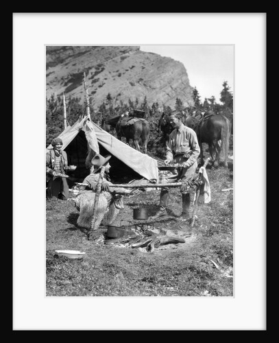 1920s 1930s two men and one woman eating a meal around a campfire with a tent and horses at baker lake alberta canada by Anonymous