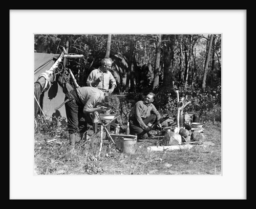 1930s three men at campsite one washing his face at tripod wash stand the other tending campfire lake of the woods ontario canada by Anonymous