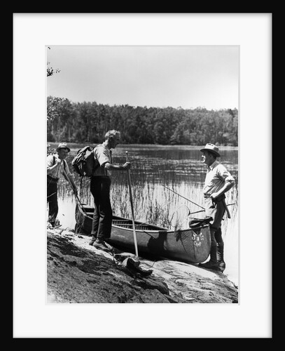 1930s three fishermen standing beside canoe holding fishing gear net backpack lake of the woods ontario by Anonymous