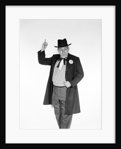 1950s 1960s man wearing old-time politician frock coat with campaign pin back button pointing index finger in air looking at camera by Anonymous
