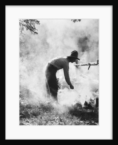 1920s 1930s man cowboy cook bending over campfire by Anonymous