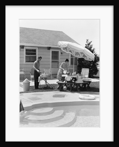 1960s summer outdoor family of four backyard barbeque by pool father grilling mother serving lemonade to son and daughter by Anonymous