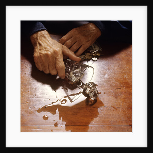 1980s hand holding spilled alcoholic drink on bar with keys in other hand by Anonymous