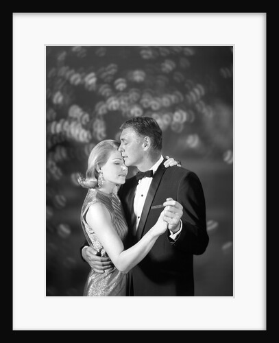 1960s couple woman in evening dress and man in tuxedo slow dancing by Anonymous