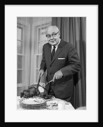 1960s man carving thanksgiving roast turkey dinner looking at camera by Anonymous