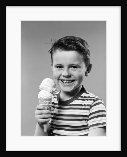 1950s smiling boy eating double dip ice cream cone looking at camera by Anonymous