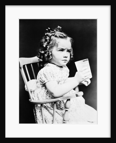 1930s child girl sitting in high chair holding glass of milk serious look bow in hair baloney curls by Anonymous