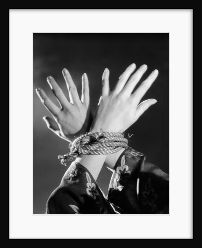 1930s woman's hands tied together by rope overhead view by Anonymous