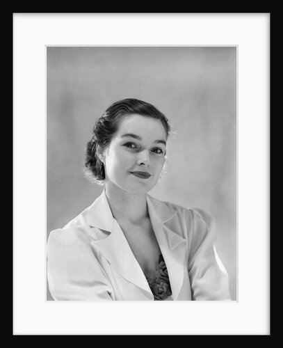 1930s portrait of young brunette woman looking at camera half smiling wearing white jacket with lapels by Anonymous