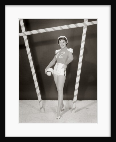 1950s 1960s woman in sexy football costume at goalpost by Anonymous
