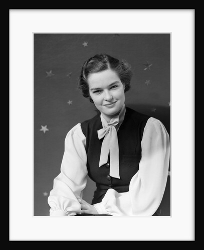 1930s woman portrait smiling star printed backdrop wearing vest bow collar looking at camera by Anonymous
