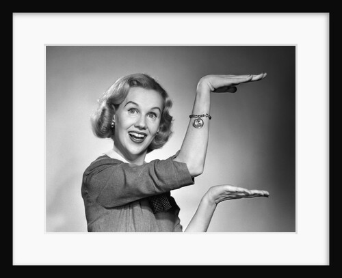 1950s 1960s happy smiling blond woman gesturing with hands showing size of something looking at camera by Anonymous