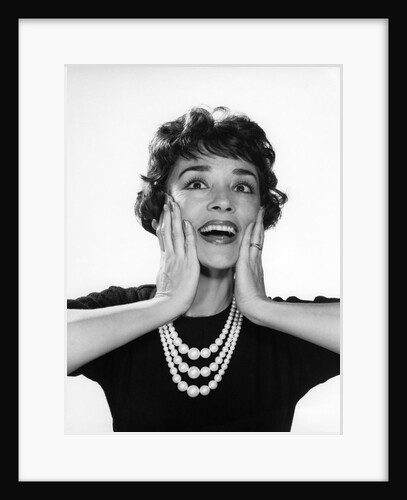 1950s 1960s woman 3 strand necklace hand up to cheeks happy smiling by Anonymous