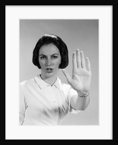 1960s woman looking at camera holding up hand palm forward commanding stop by Anonymous