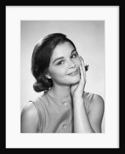 1960s smiling brunette young woman hand to cheek facial expression gesture looking at camera by Anonymous