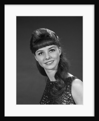 1960s portrait of smiling young woman in sequin dress looking at camera by Anonymous