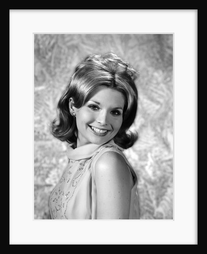 1960s portrait smiling blond woman looking at camera over shoulder by Anonymous