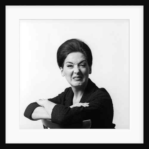 1960s 1970s brunette middle aged woman making funny face looking at camera with wrinkled nose and arms folded on back of chair by Anonymous