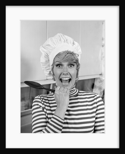 1970s woman portrait wearing chef's toque in kitchen with surprised face looking at camera by Anonymous