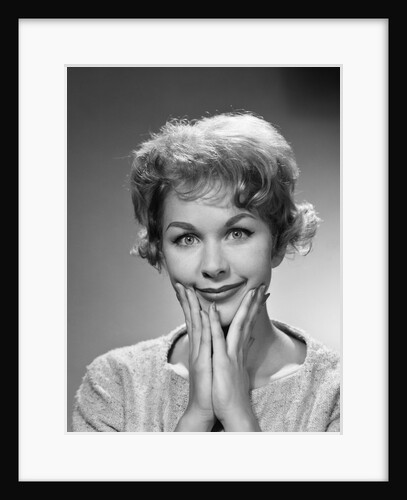 1950s 1960s happy bemused woman facial expression both hands to chin smile looking at camera by Anonymous