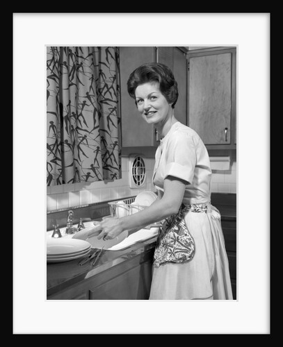 1960s woman housewife washing dishes in kitchen sink looking at camera by Anonymous