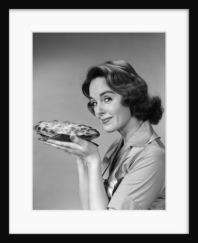 1950s 1960s woman smiling holding freshly baked pie looking at camera by Anonymous