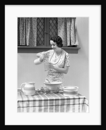 1920s 1930s woman pouring milk into measuring cup by Anonymous
