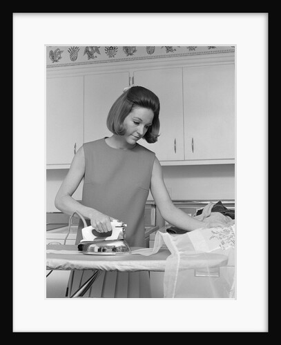 1970s woman ironing an apron with steam iron by Anonymous