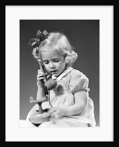 1940s little blond girl talking on toy telephone by Anonymous
