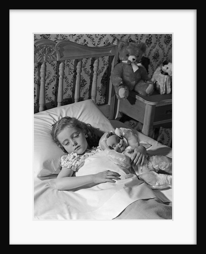 1950s 1960s little girl sleeping in bed with arm around a doll by Anonymous