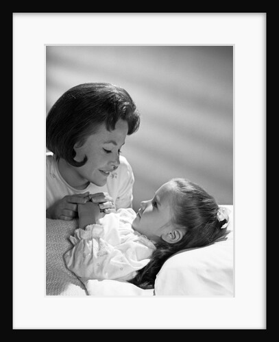 1960s daughter with mother tucking into bed by Anonymous