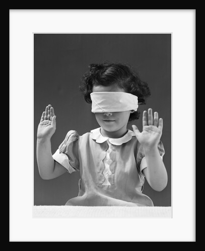 1940s child wearing blind fold with hands up in the air by Anonymous
